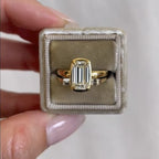 Gold ring with a diamond in a jewelry box held by a hand