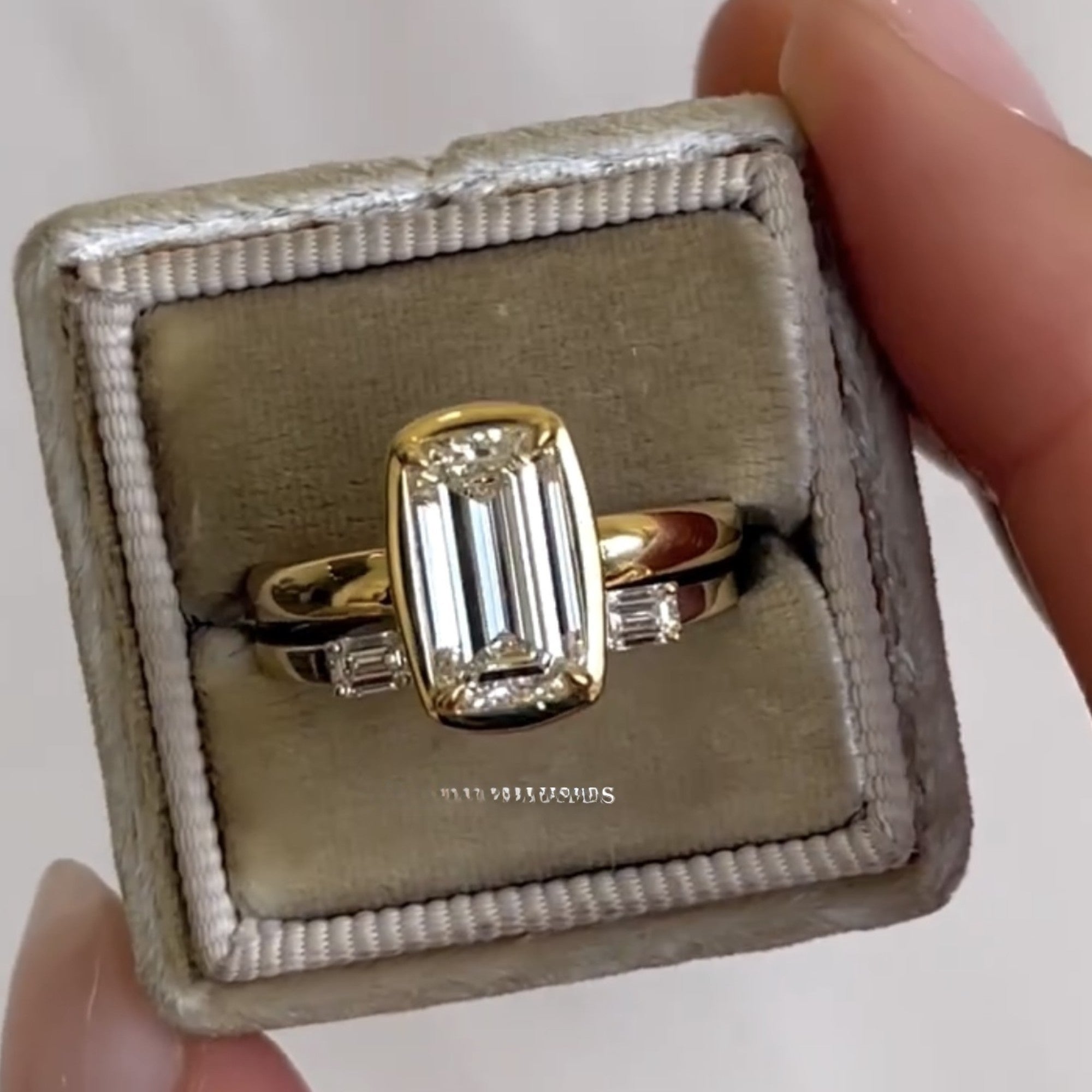 Gold ring with a large diamond in a box, branded 'The Future Diamonds'.