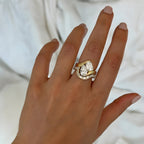 Hand wearing a gold and diamond ring on a plain 