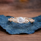 Rose gold diamond ring on a blue leaf with a blurred 