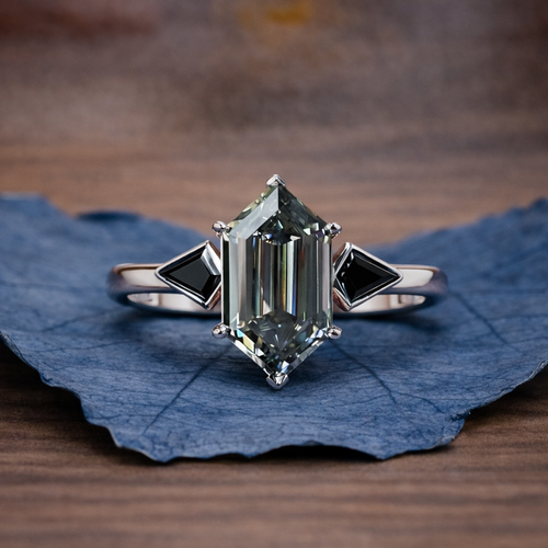 Silver ring with a large green gemstone on a blue leaf