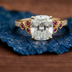 Gold ring with a large diamond and smaller red gemstones 