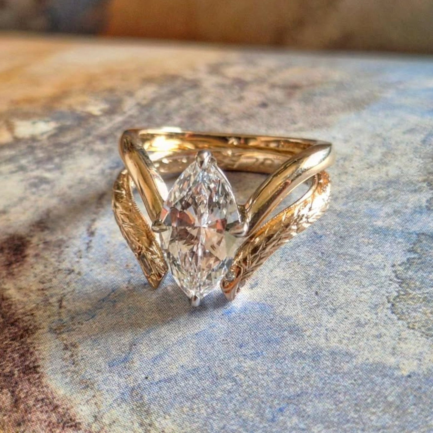 Gold ring with a large diamond on a textured stone surface
