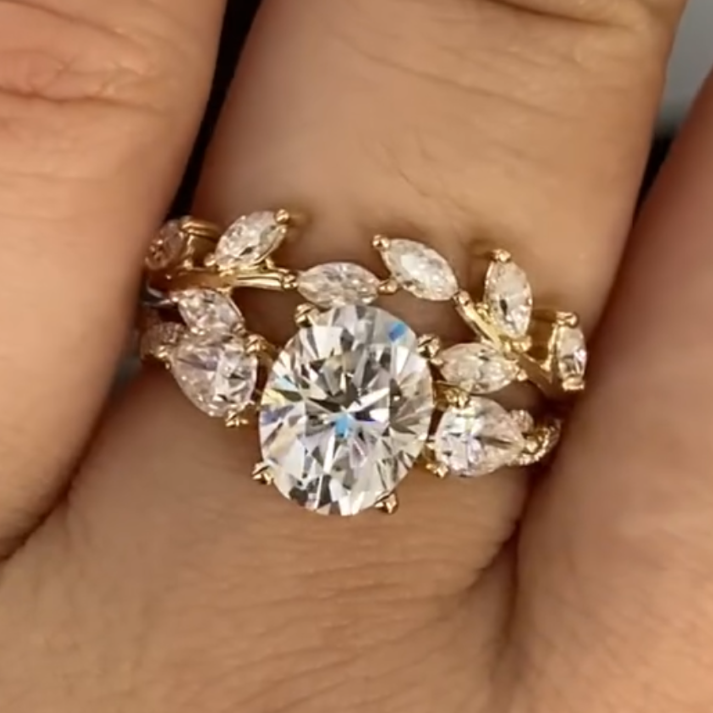 Gold ring with a large diamond and smaller stones on a hand