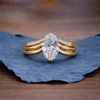 Gold ring with a pear-shaped diamond on a blue leaf