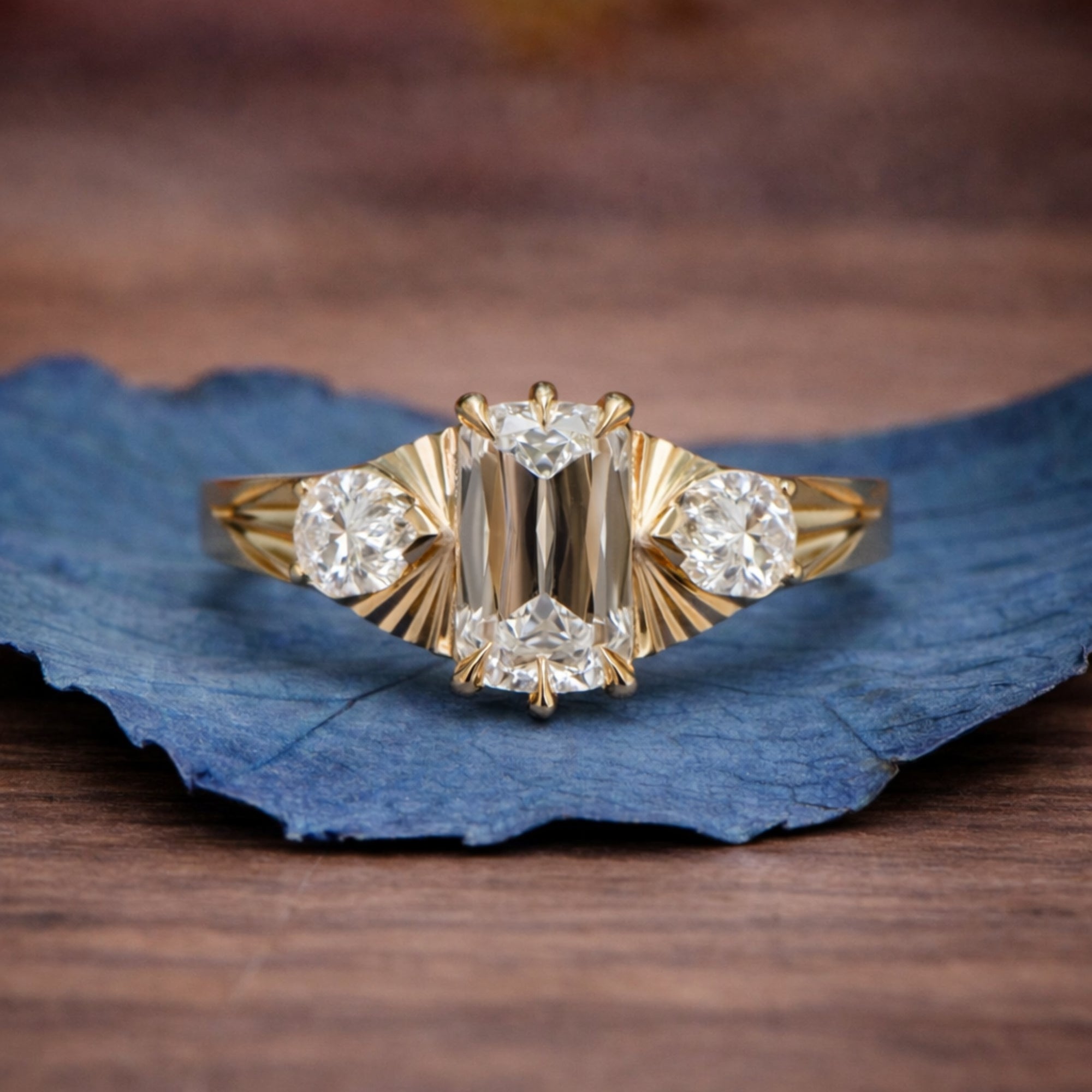 Gold ring with diamonds on a blue leaf