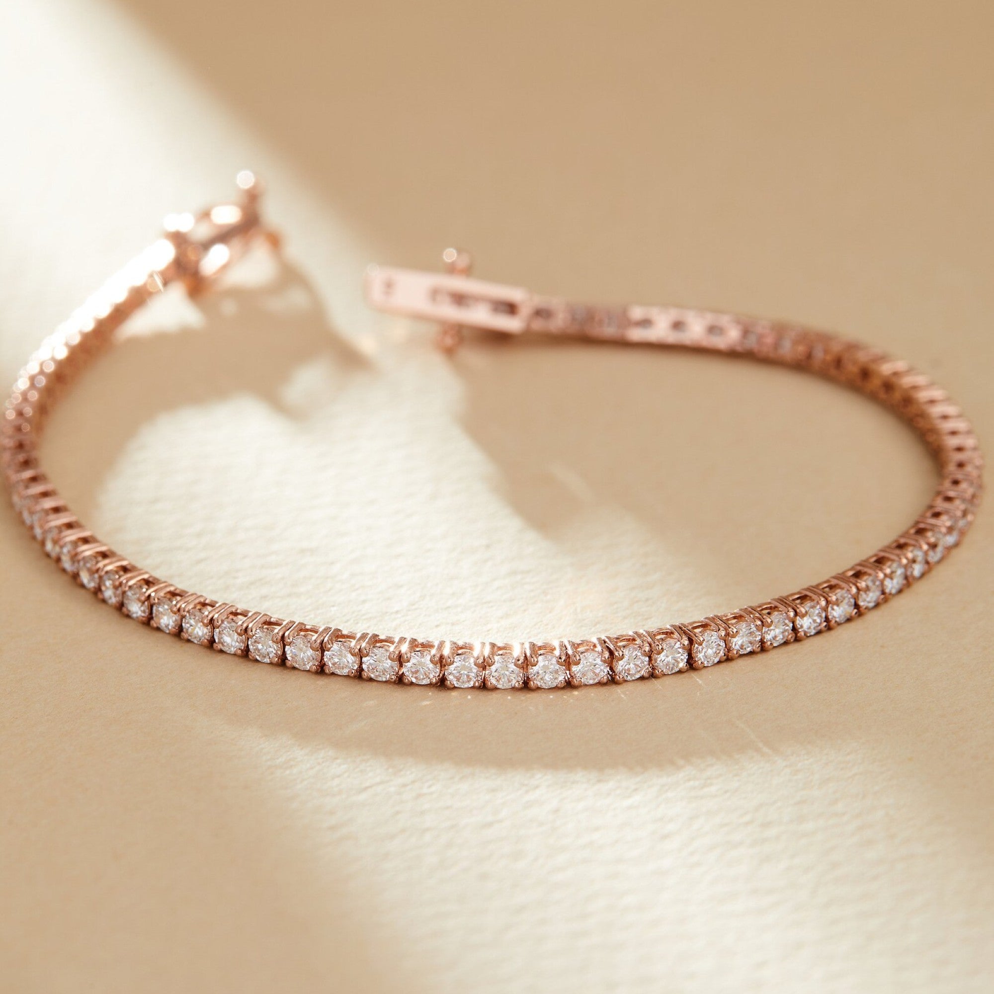 Rose gold bracelet with diamonds on a beige 