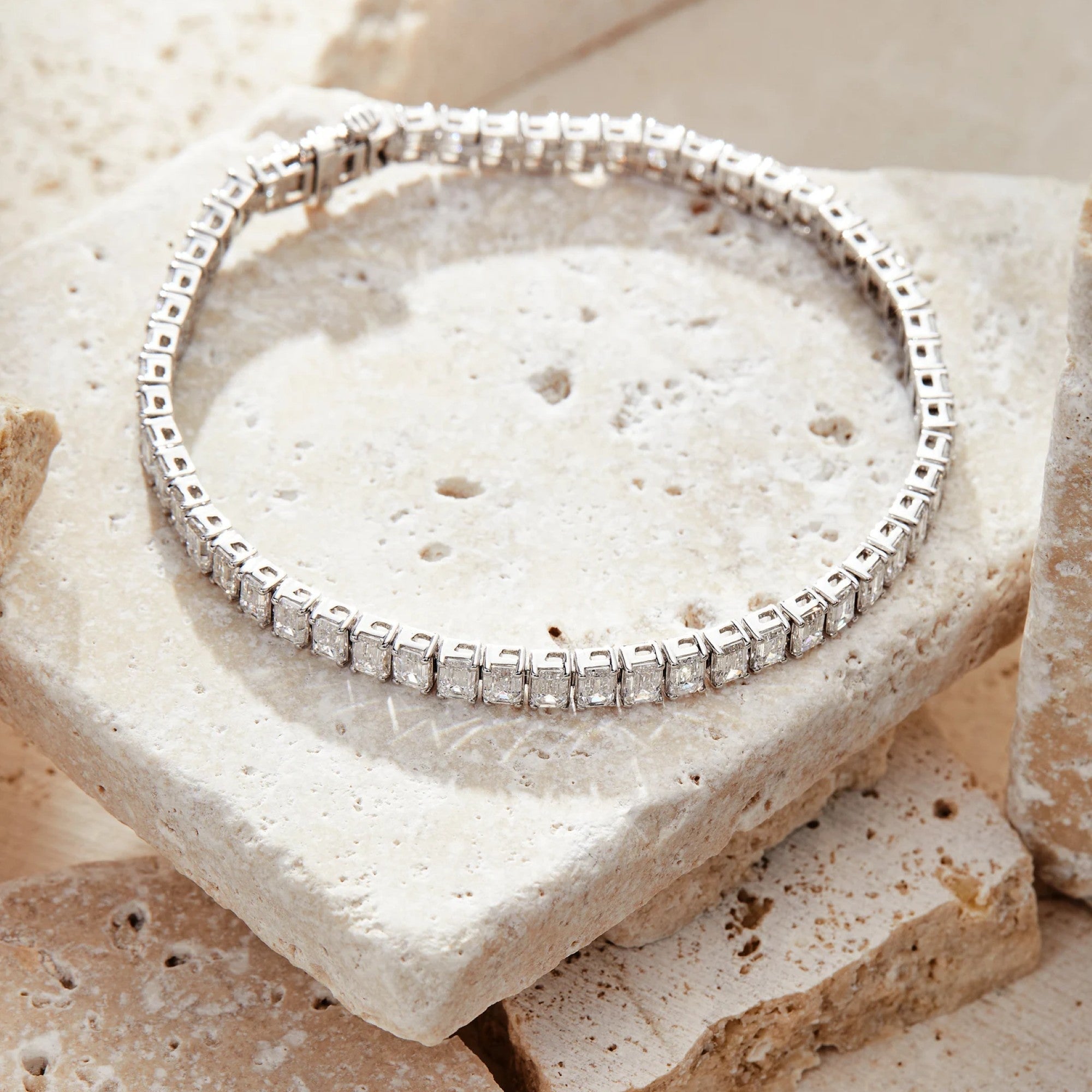 Silver bracelet with clear stones on a textured stone surface