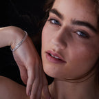 Close-up of a woman wearing a diamond bracelet with a dark 