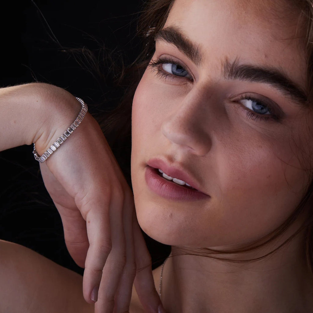 Close-up of a woman wearing a diamond bracelet with a dark 