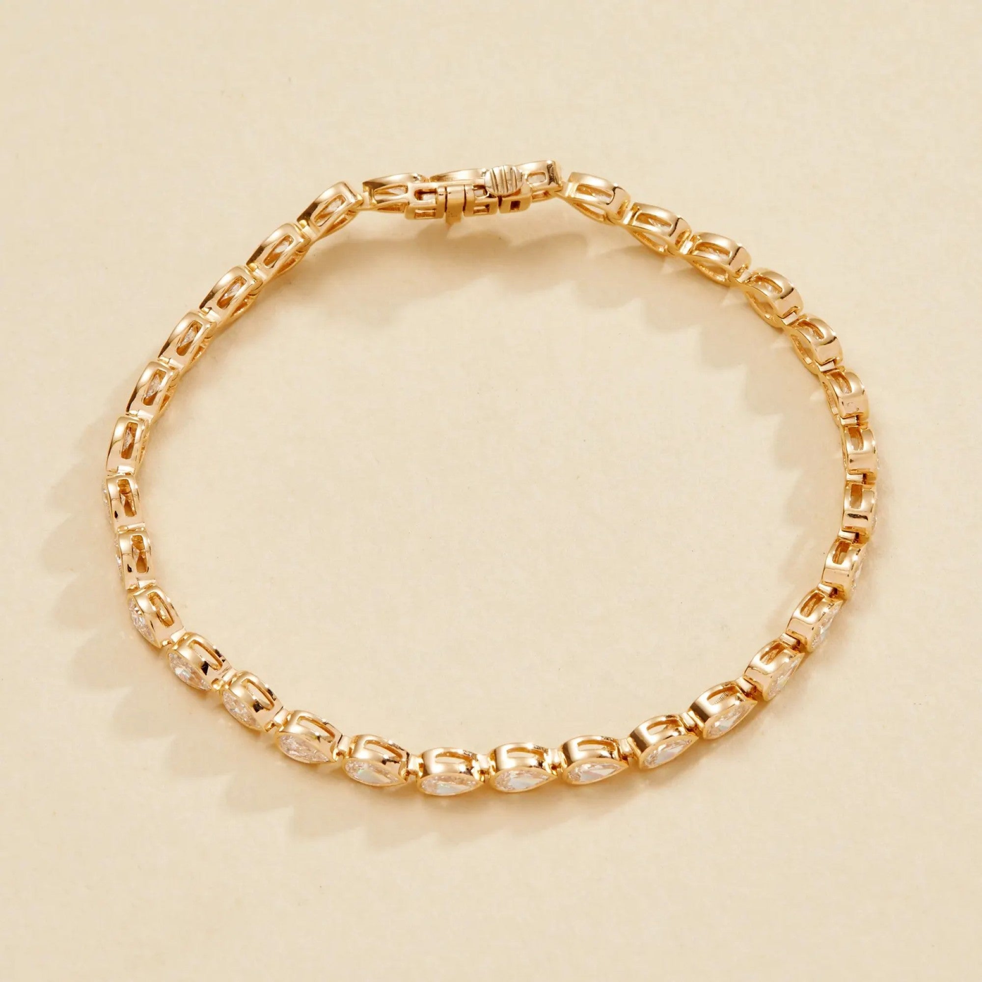 Gold bracelet on a beige 