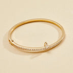 Gold bracelet with small diamonds on a beige 
