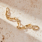 Gold bracelet with geometric design on a beige surface