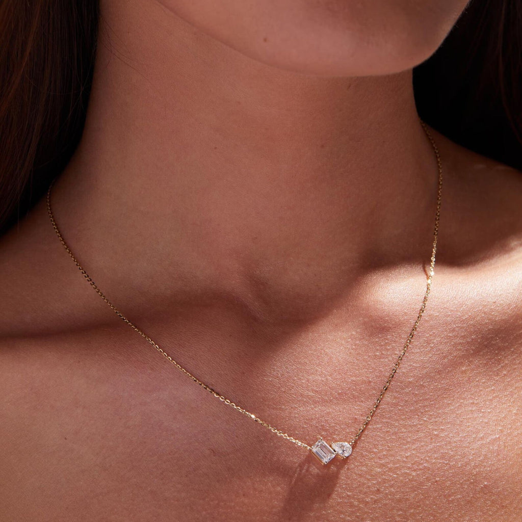 Gold necklace with a diamond pendant on a person's neck