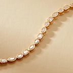 Gold bracelet with diamond-like stones on a beige 
