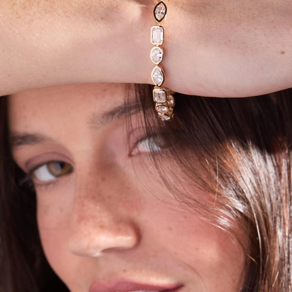 Close-up of a woman wearing a rose gold hoop earring.