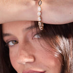 Close-up of a woman wearing a rose gold hoop earring.