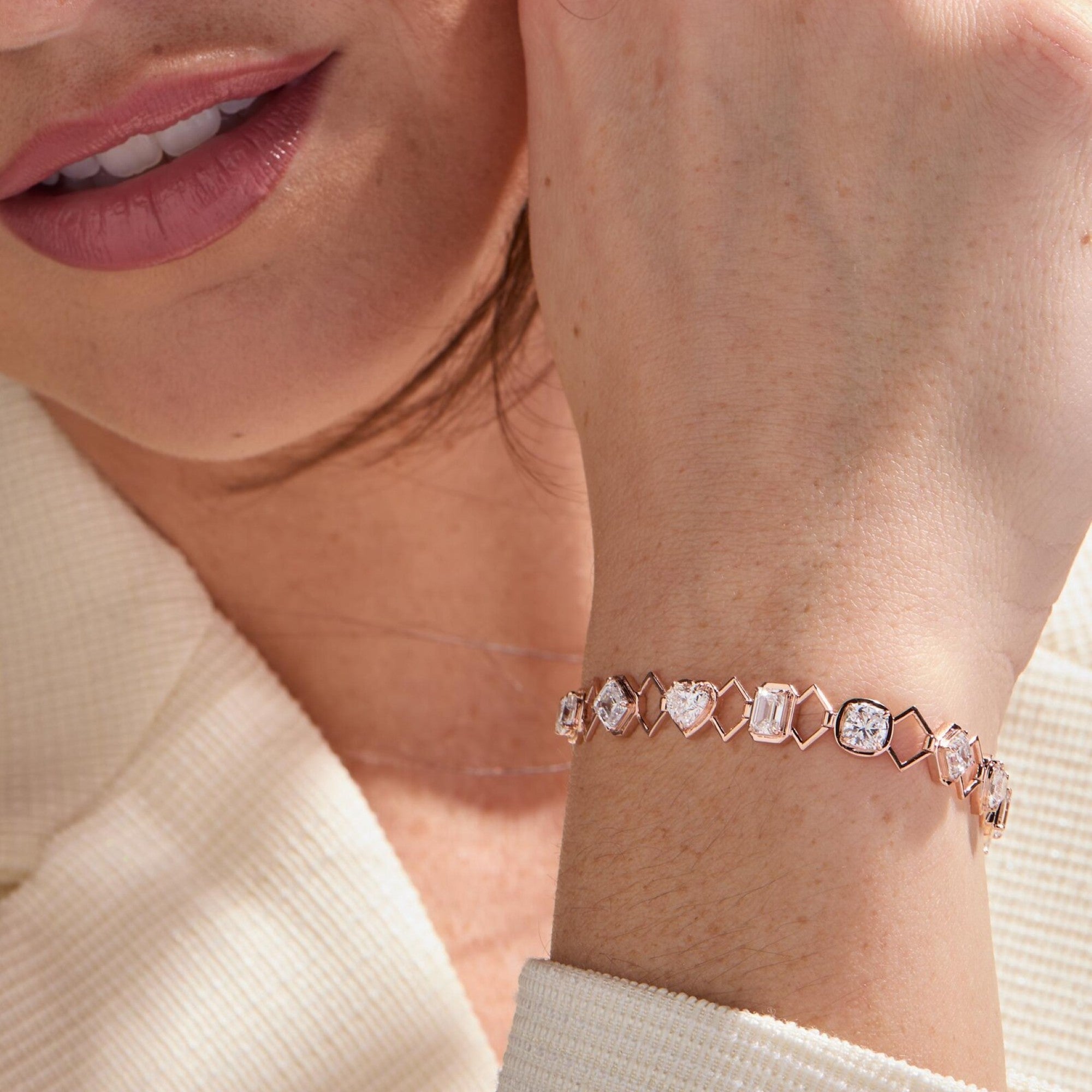 Close-up of a person wearing a rose gold bracelet with gemstones.