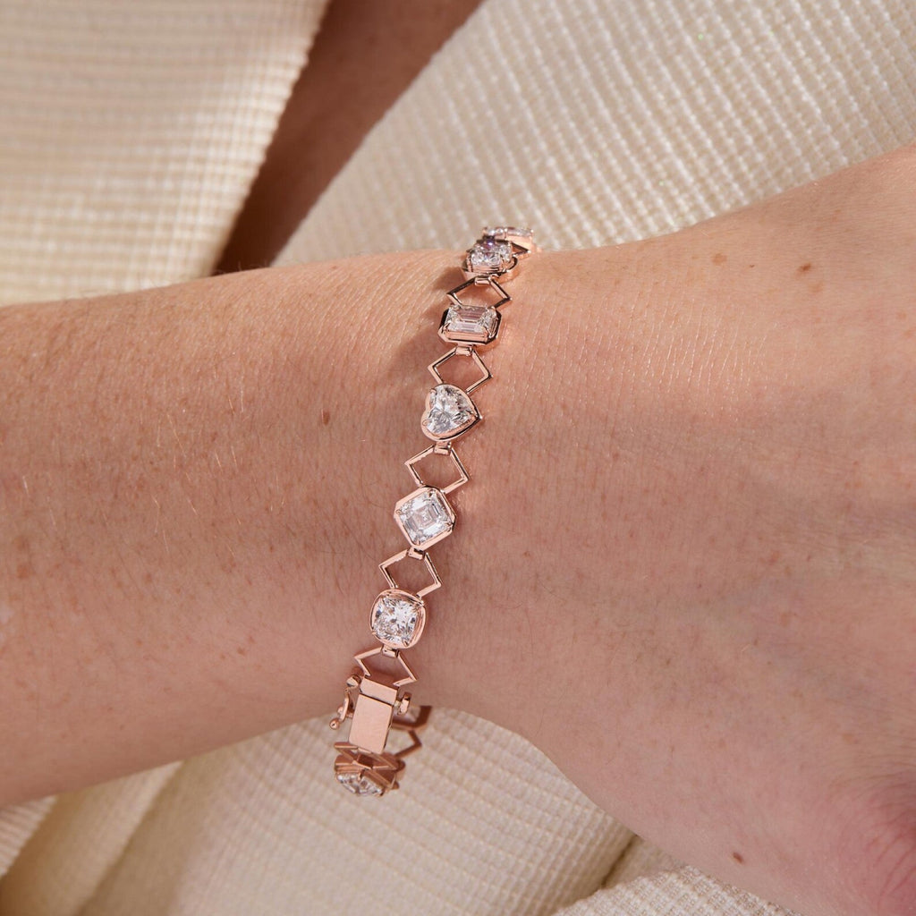 Rose gold bracelet with clear stones on a wrist against a neutral background