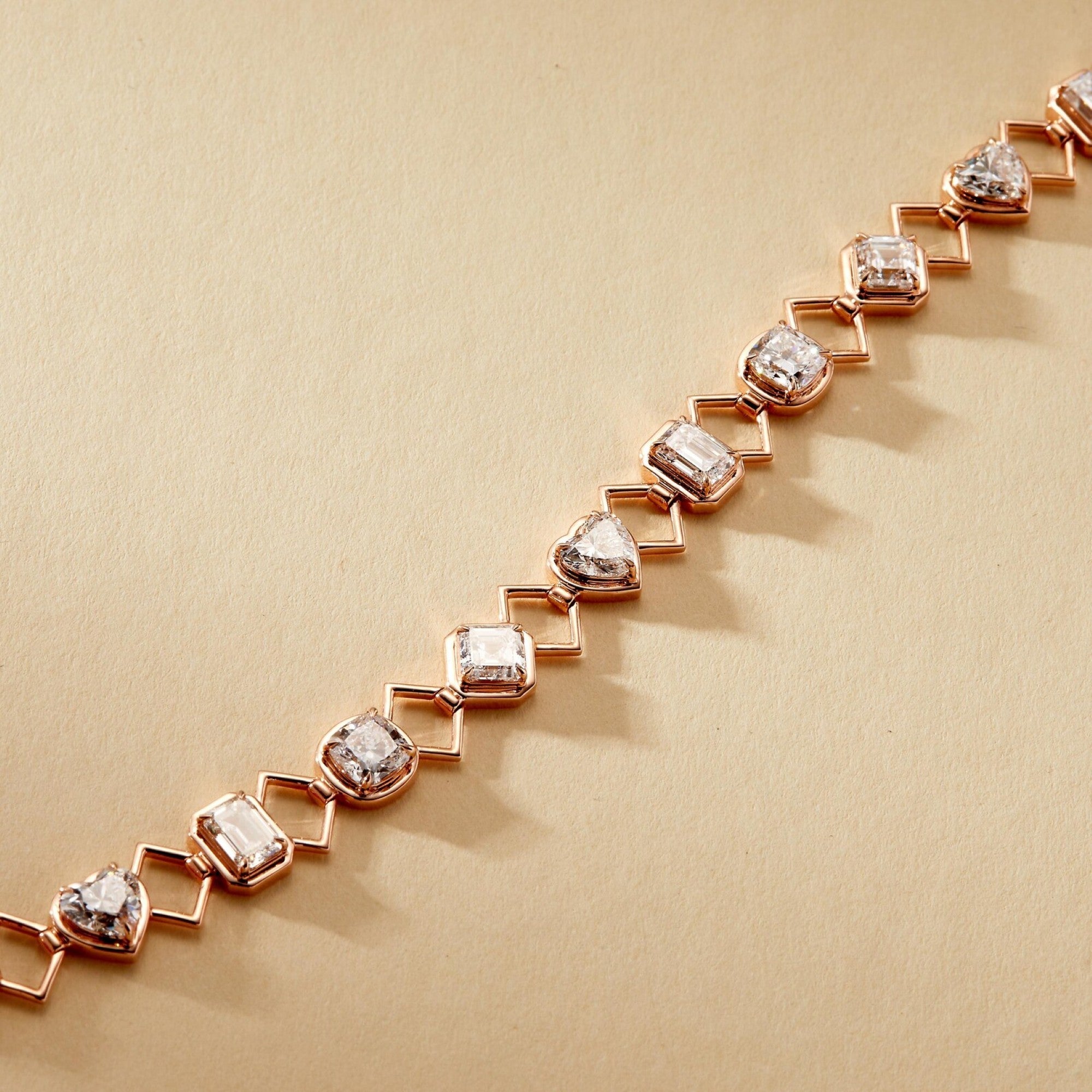 Rose gold bracelet with diamond-like stones on a beige 