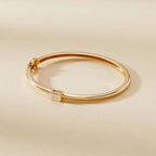 Gold bracelet with a diamond on a beige 