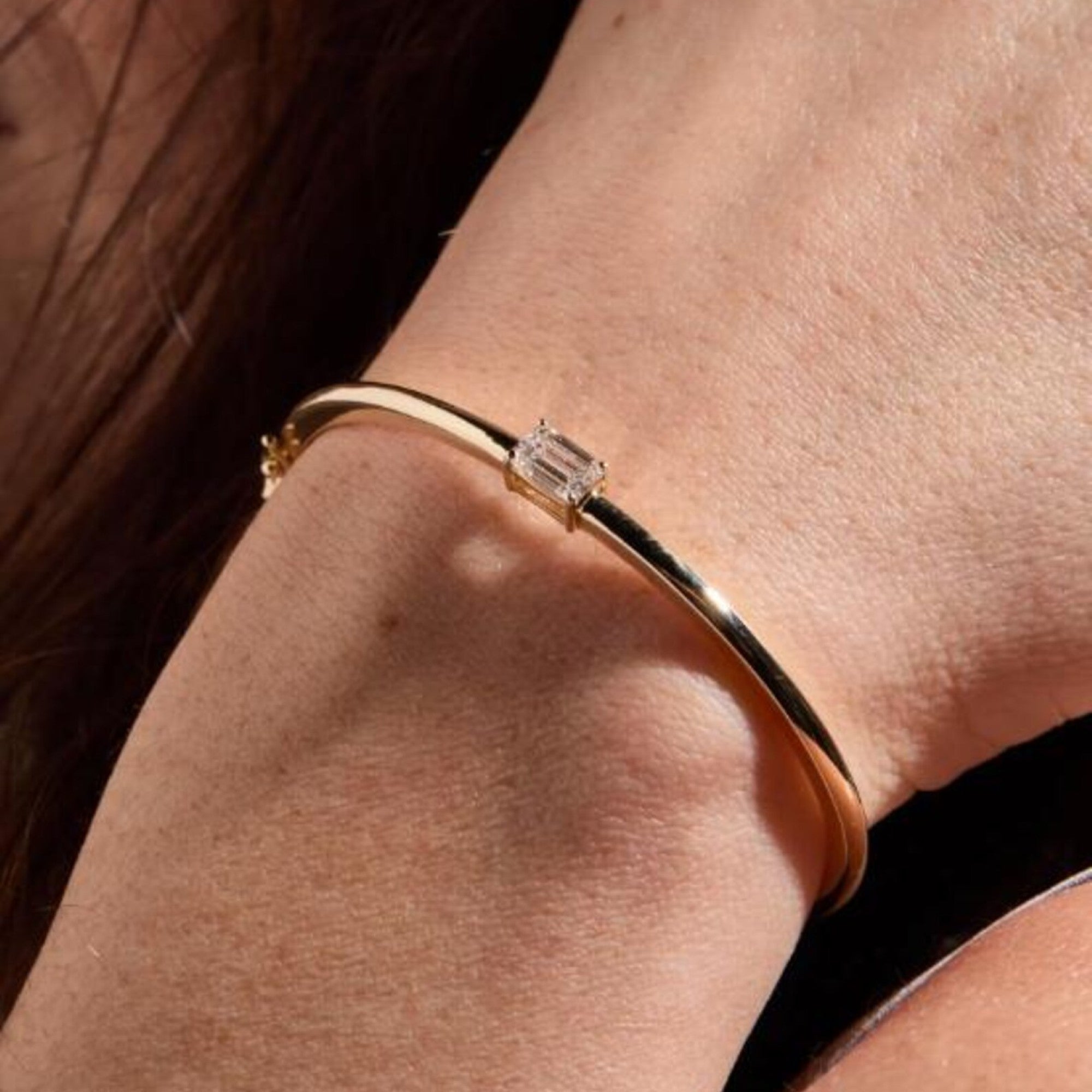 Gold bracelet with a diamond on a wrist