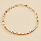 Gold bracelet with diamond accents on a beige 
