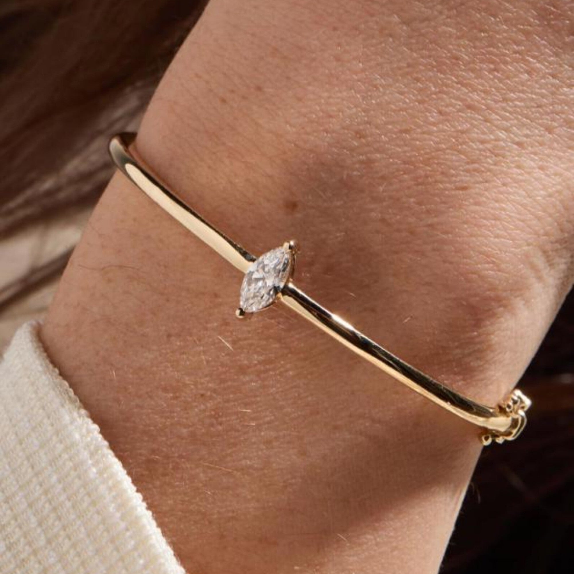 Gold bracelet with a diamond on a wrist