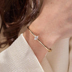 Gold bracelet with a diamond on a person's wrist