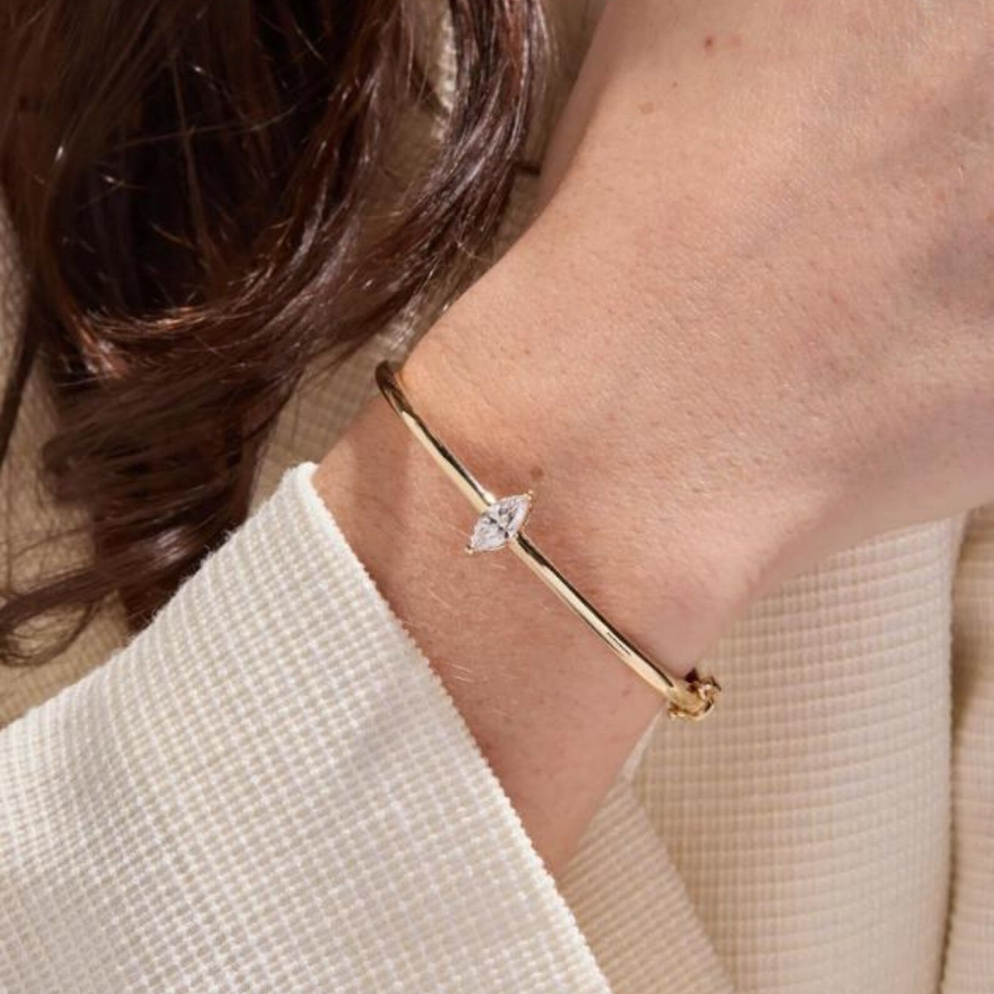 Gold bracelet with a diamond on a person's wrist