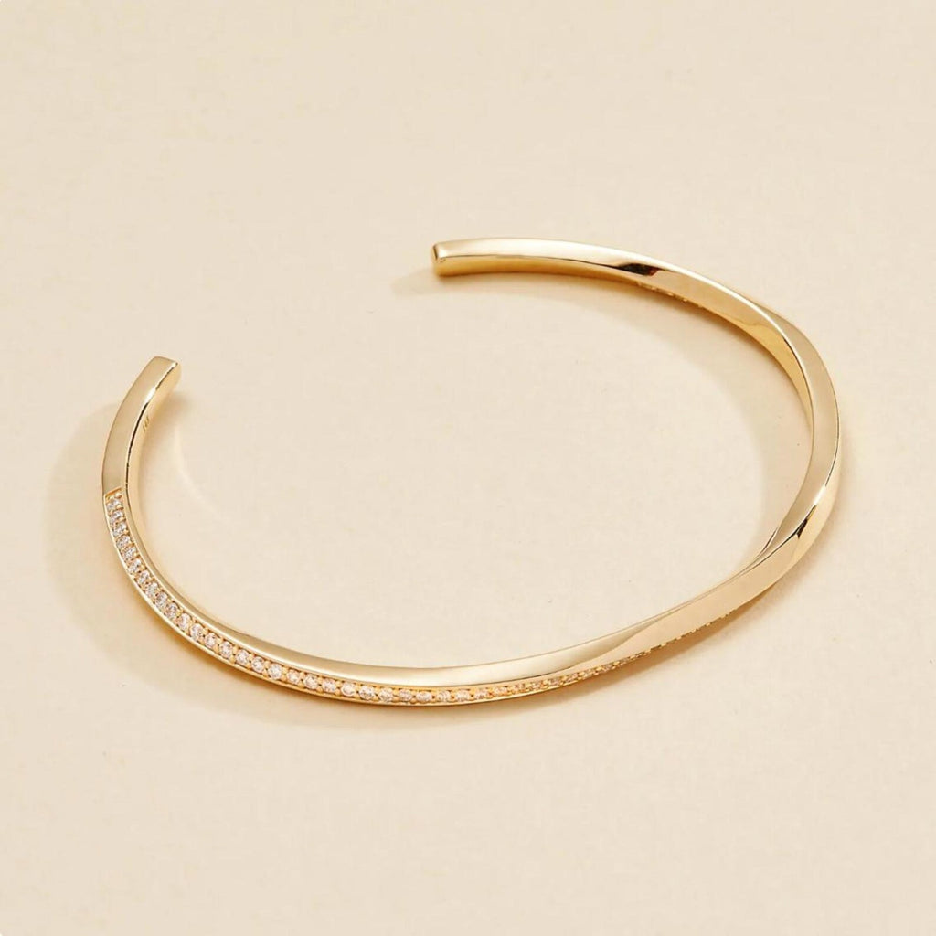 Gold bracelet on a beige 