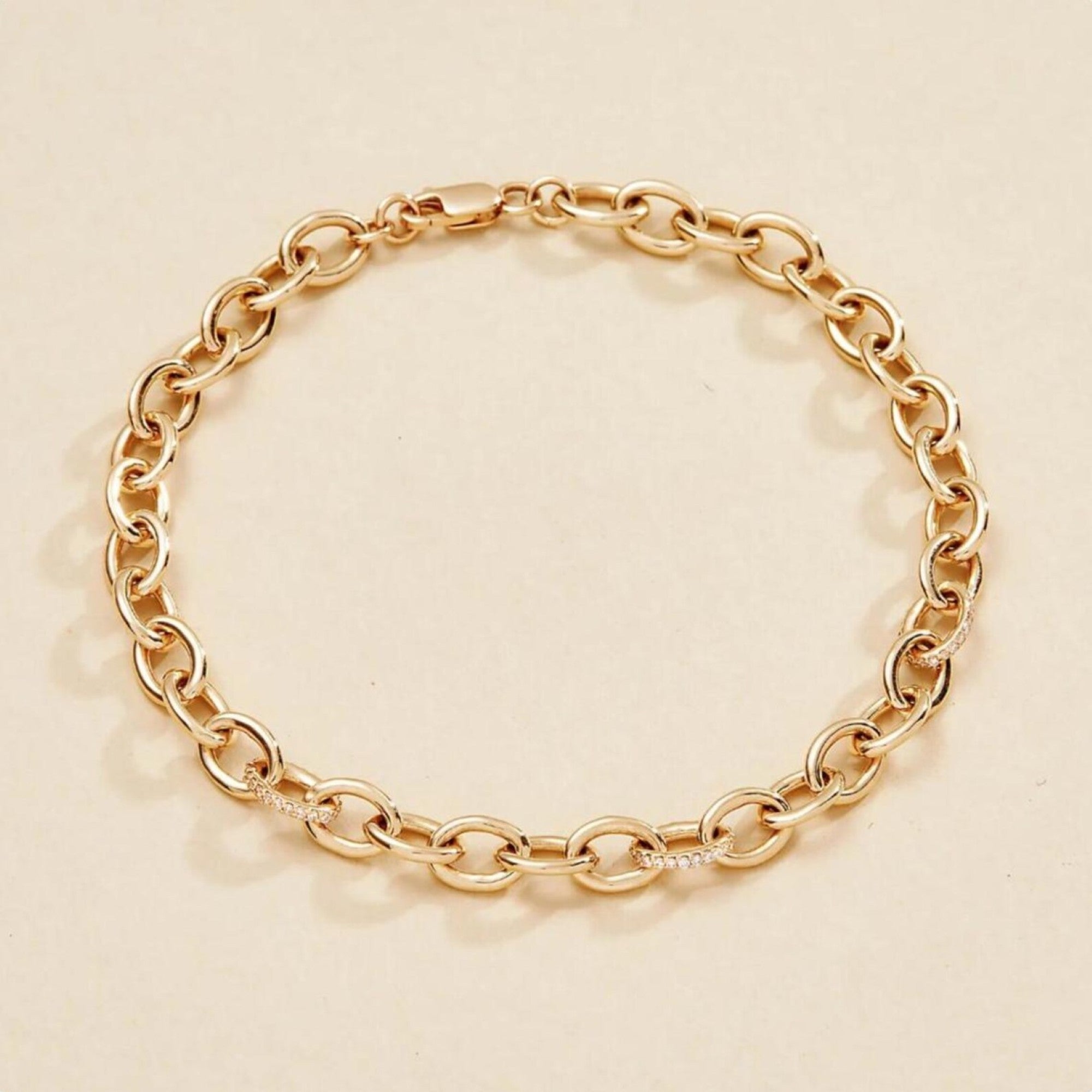Gold chain bracelet on a beige 