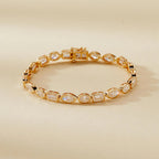 Gold bracelet with clear gemstones on a beige 