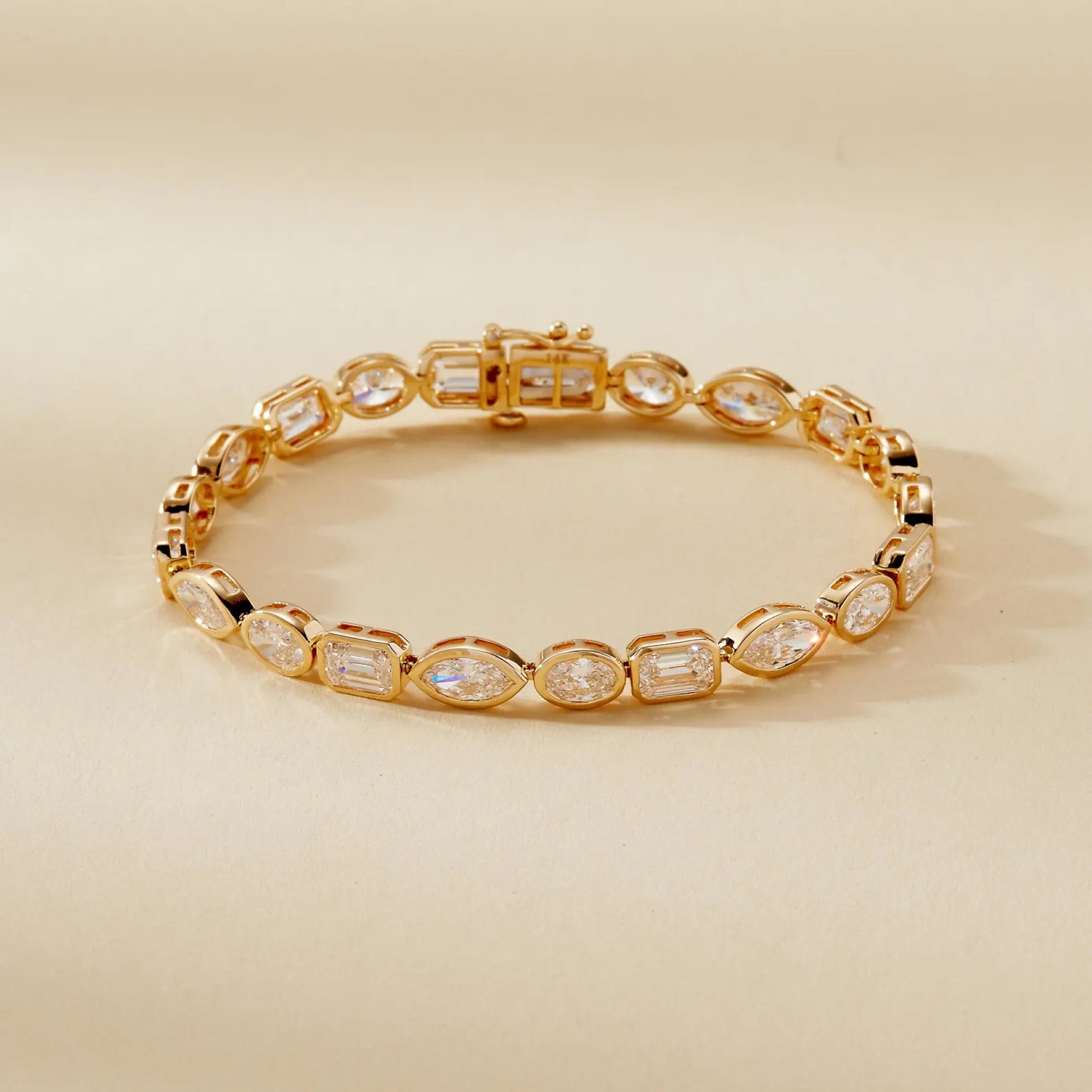 Gold bracelet with clear gemstones on a beige 