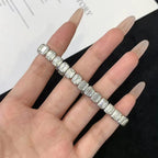 Hand wearing a diamond bracelet on a white 
